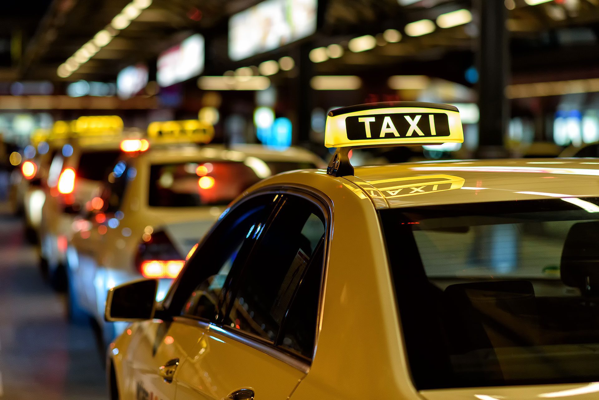 Charlotte taxi yellow taxis lining up at cab rank, with lighted taxi sign on roof