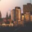Downtown Ottawa skyline at sunset, with historic Parliament buildings and modern high-rises lit by golden hour light—capturing a typical view seen en route to the city by airport taxi in Ottawa.
