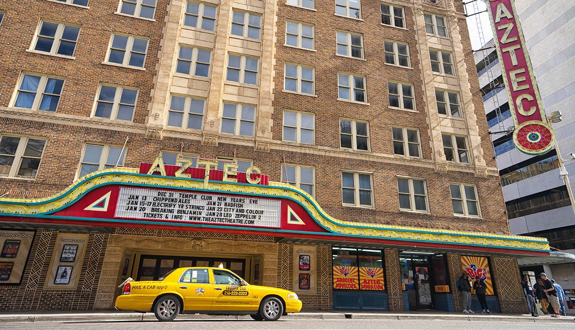 san antonio taxi yellow taxi vehicle outside of high rise Aztec theatre building