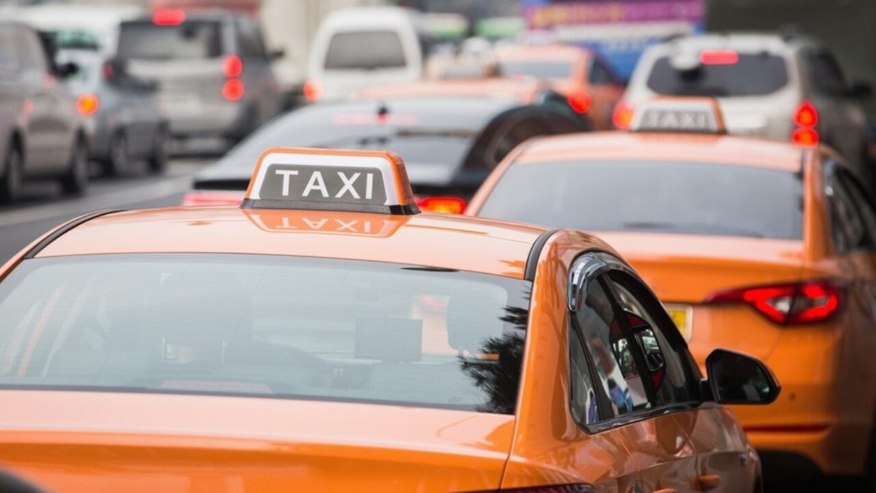Seoul taxi orange taxis with signature sign on roof driving in a busy street