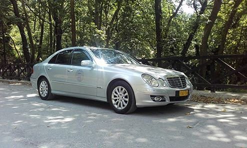 Volos taxi silver vehicle with yellow registration near a forest