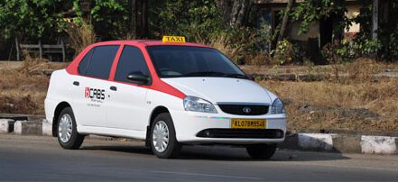 Cochin taxi white vehicle with a red roof with a signature yellow roof sign and car plate