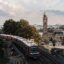 aerial view on Hamburg hochbahn train and Landugsbrücke clock tower near trees under a cloudy sky at daytime