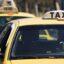 yellow taxis with signature taxi sign on their roof waiting behind one another at daytime