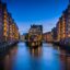 nighttime shot of ;ighted buildings in the middle and on the sides of