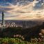 sun appearing behind clouds in the sky over the Taipei city centre