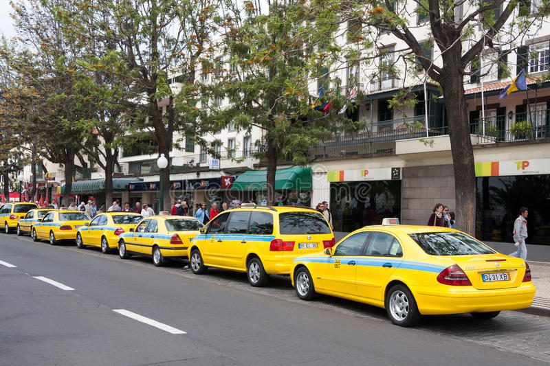 funchal taxi taxis lining up by the pavement on a busy road