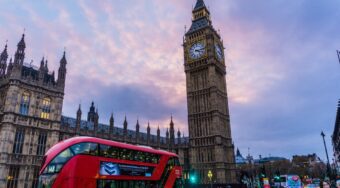 London city centre, an image of Big Ben and a red double-decker bus driving by.