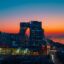 lighted city buildings near body of water at golden hour