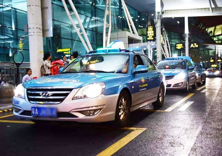 Guangzhou taxi taxis lined up half with blue top and roof sign, silver bottom