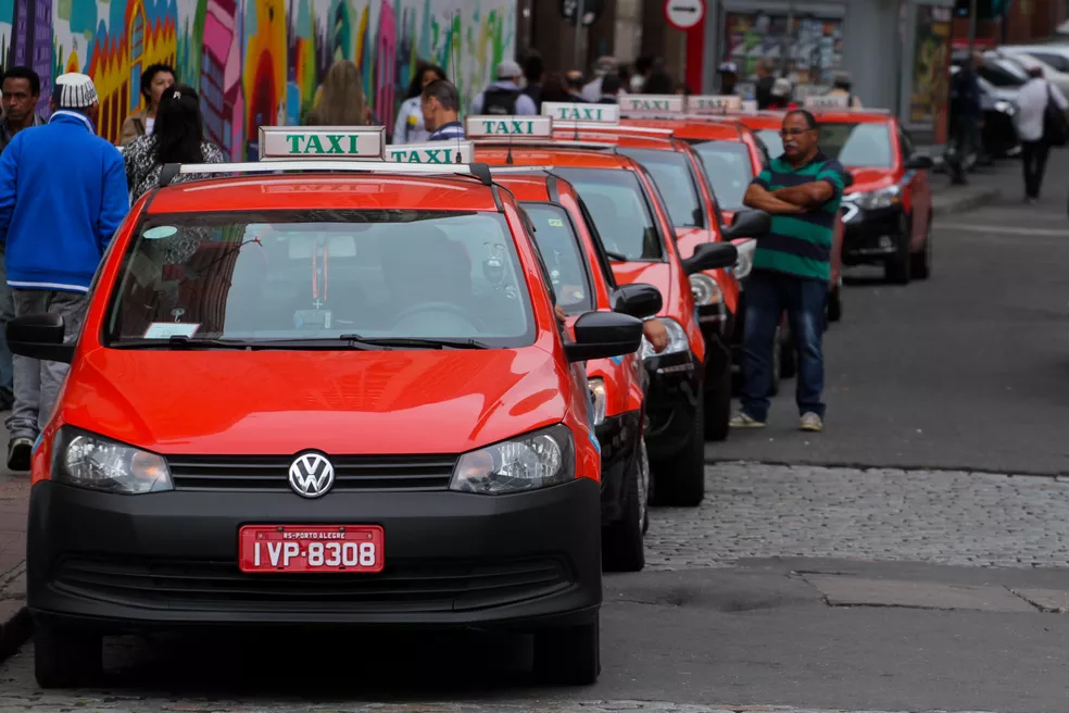 Porto Alegre taxi cab rank with red taxi vehicles with a signature white sign on their roof and green letters reading 'taxi'