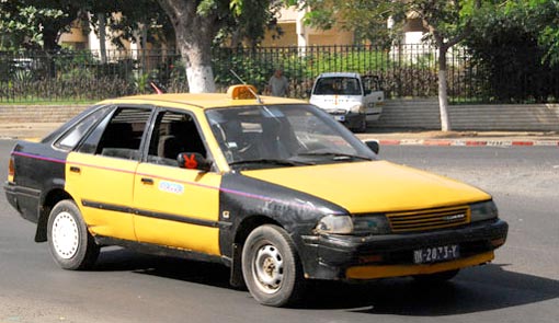 Dakar taxi yellow and black sedan vehicle with a signature yellow sign on the roof