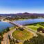Commonwealth avenue and bridge over Burley Griffin lake in Canberra between city CBD and federal government capital hill triangle area with local streets, roads, parks and buildings.