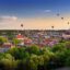 Beautiful summer panorama of Vilnius old town with colorful hot air balloons in the sky, taken from the Gediminas hill