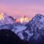 photo of the snowy mountain, with the sun highlighting the peaks with some pink and blue tones in Verbier, Alps, Canton du Valais, Wallis, Switzerland