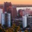 sunset shot of high rise city buildings with body of water in the background