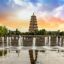 monumental Buddhist pagoda surrounded by green trees and
