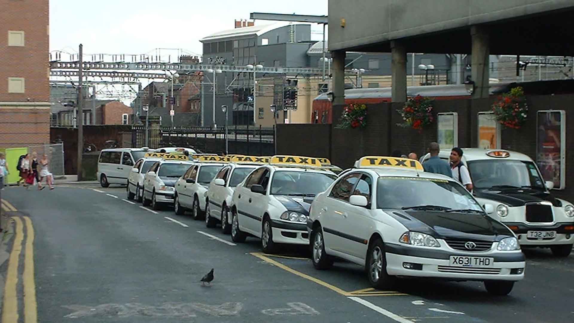 Leeds taxi yellow and black coloured taxis with a large yellow taxi sign on their roof