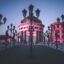 old school street light poles with three lights and statues of people dotted around a bridge with white buildings in the background