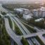 aerial view of motorways, green trees and city buildings