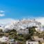 white houses on a hilltop under a blue sky with some clouds during the day