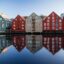 colourful houses reflecting on body of water under a clear blue sky