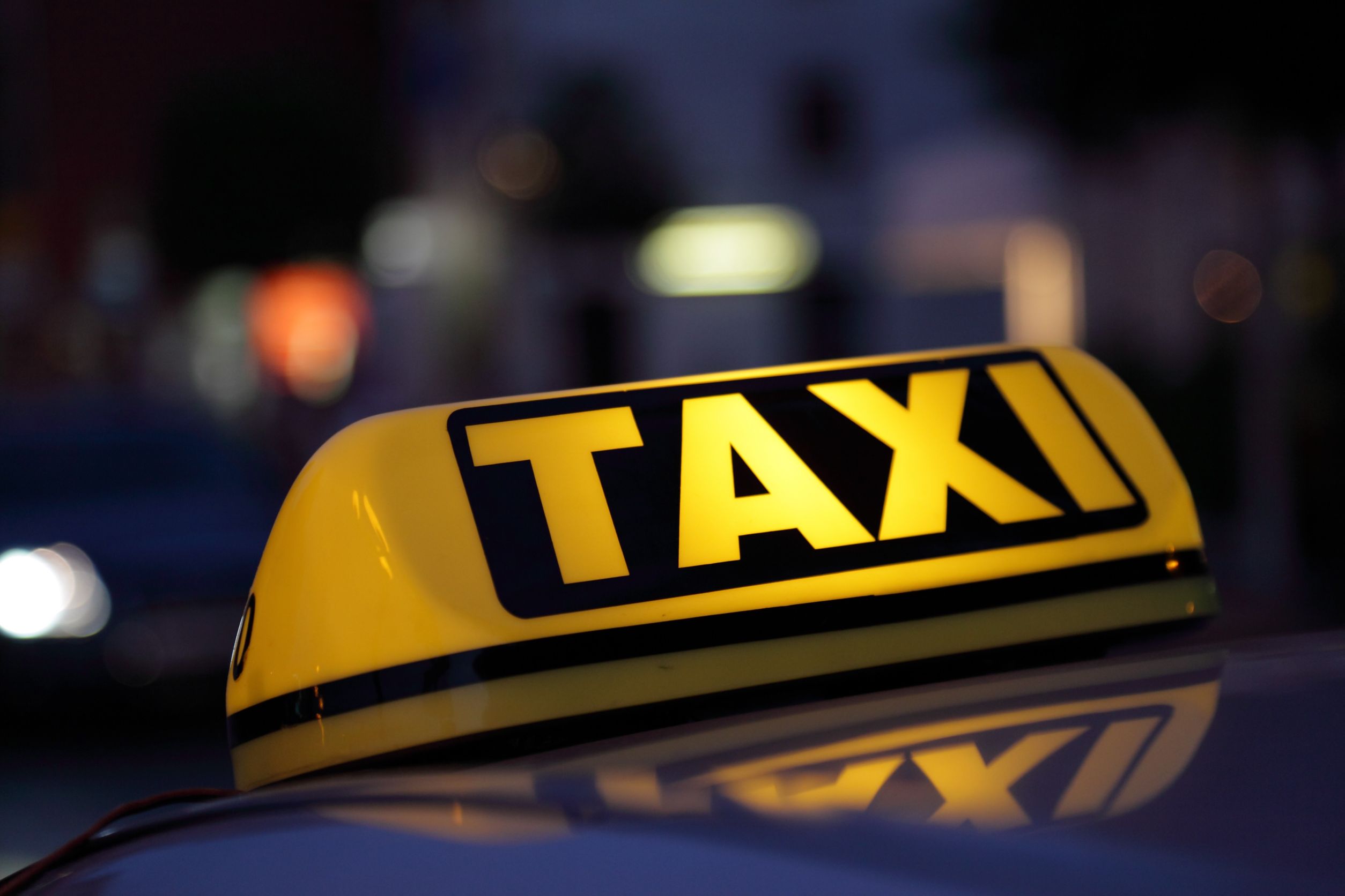 Bern Taxi lighted taxi sign in yellow and black at night time
