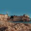 pebble beach and an old brick building by the water