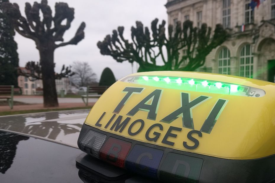 Limoges Taxi yellow roof sign on a vehicle with the words limoges taxi on it