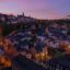 evening shot of city buildings, right after sunset, with some lighted streets and windows