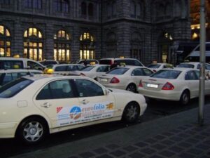 pale yellow taxi vehicles parked at taxi rank