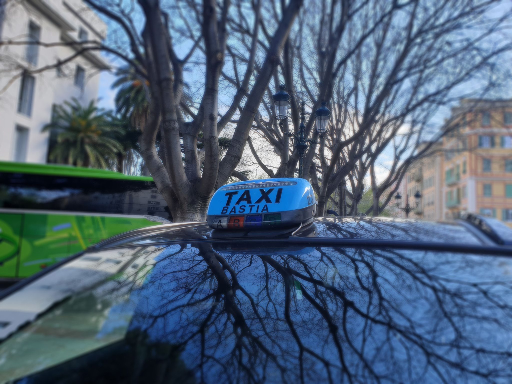 bastia taxi top of a vehicle with a white sign, stating with black letters 'taxi bastia'