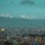 A view of Kathmandu City with snow-capped mountains behind.