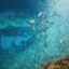 Malaysian ocean waters and green covered rocks as seen from above