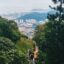 green mountains on both sides leading down to the view of a foggy city below