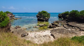 Rocks and hidden sand beaches by the waters of Coco Beach Cliff during daytime