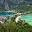Stunning view of Krabi, Thailand, with turquoise waters, towering limestone cliffs, and lush greenery under a clear blue sky.