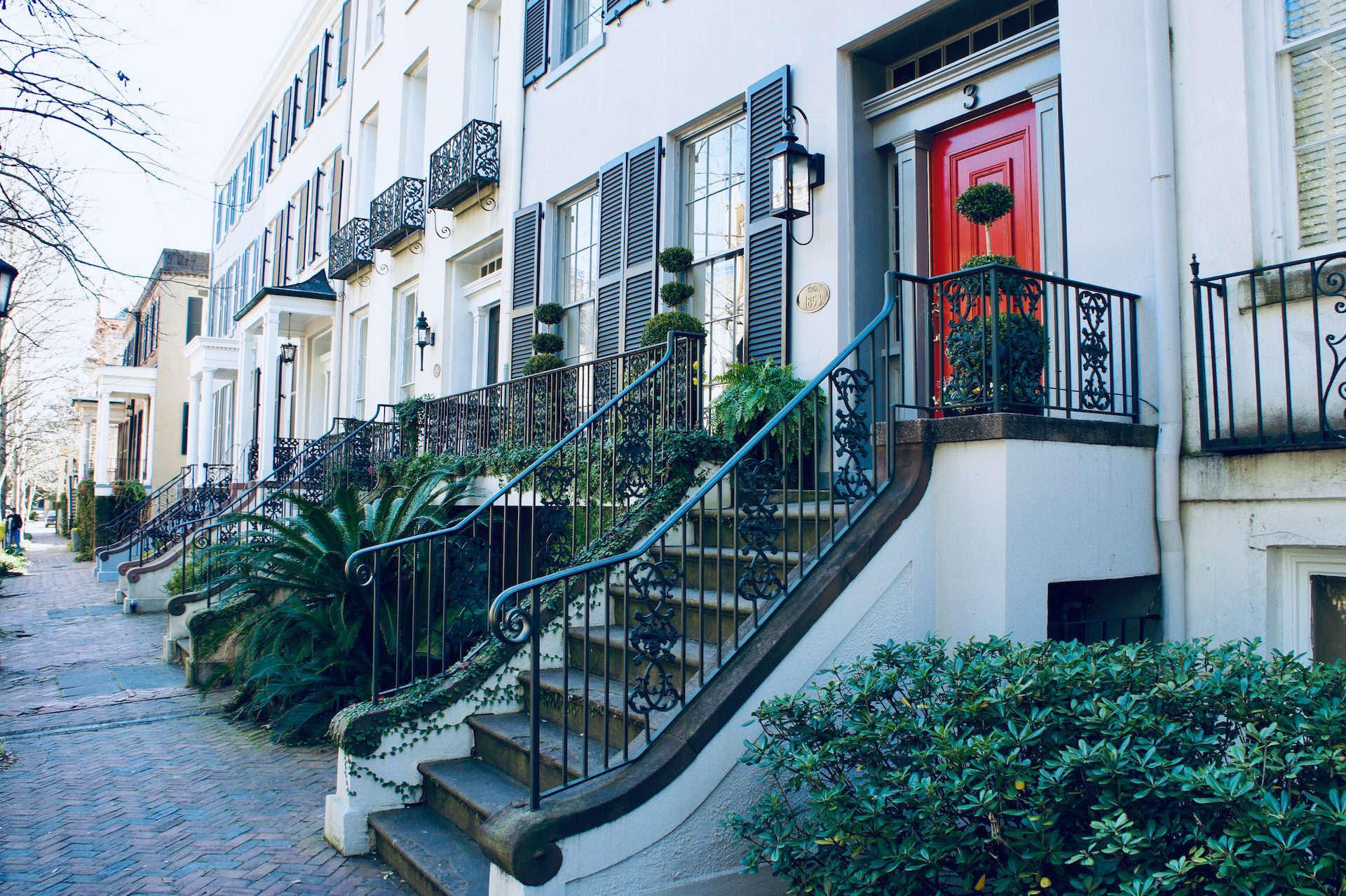 An old street in Savannah's Historic District with 19th-century homes lining the right side.