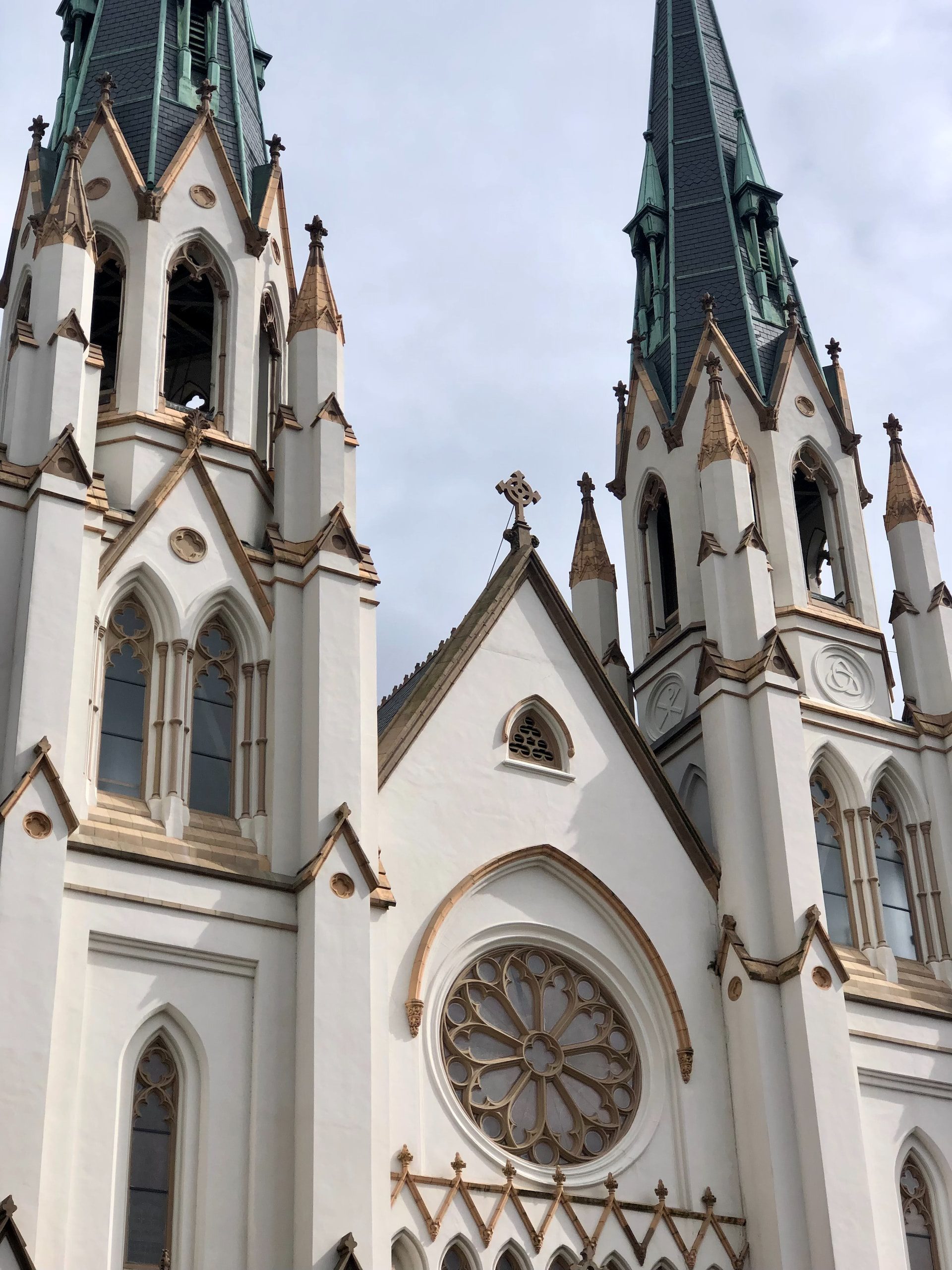 The front exterior of St, John the Baptist's Cathedral, showing two spires and classic French-Gothic architecture.