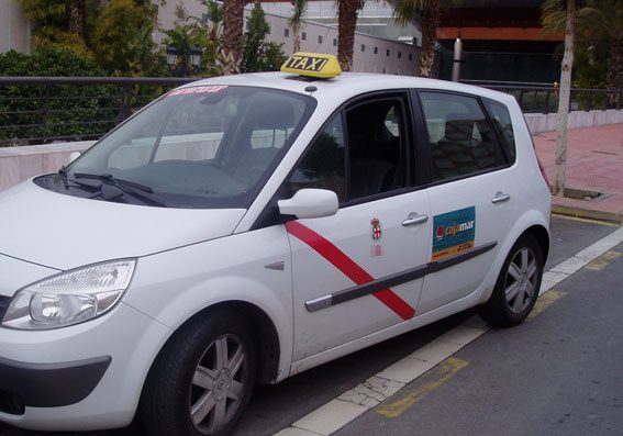 Almeria taxi Side view of a white Almeria taxi with red stripe on the door and yellow taxi sign on the roof.