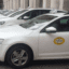 Side view of a few white Genoa Airport taxis parked next to each other.