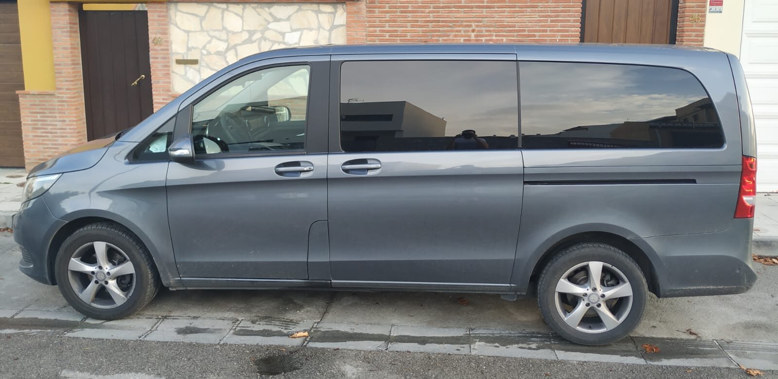 Granada Airport Taxi (Minivan) Side view of a silver/grey Granada Airport taxi (minivan) parked in front of a building.
