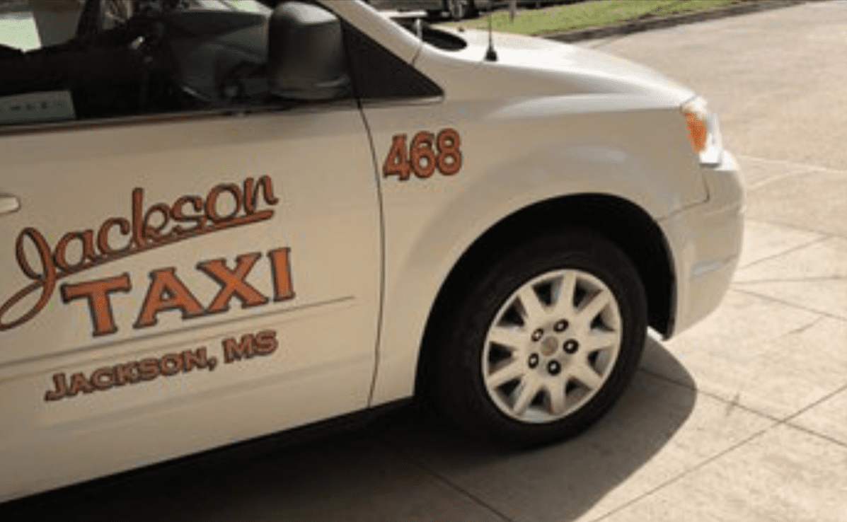 Jackson taxi, MS A white Jackson taxi with orange lettering on the door.