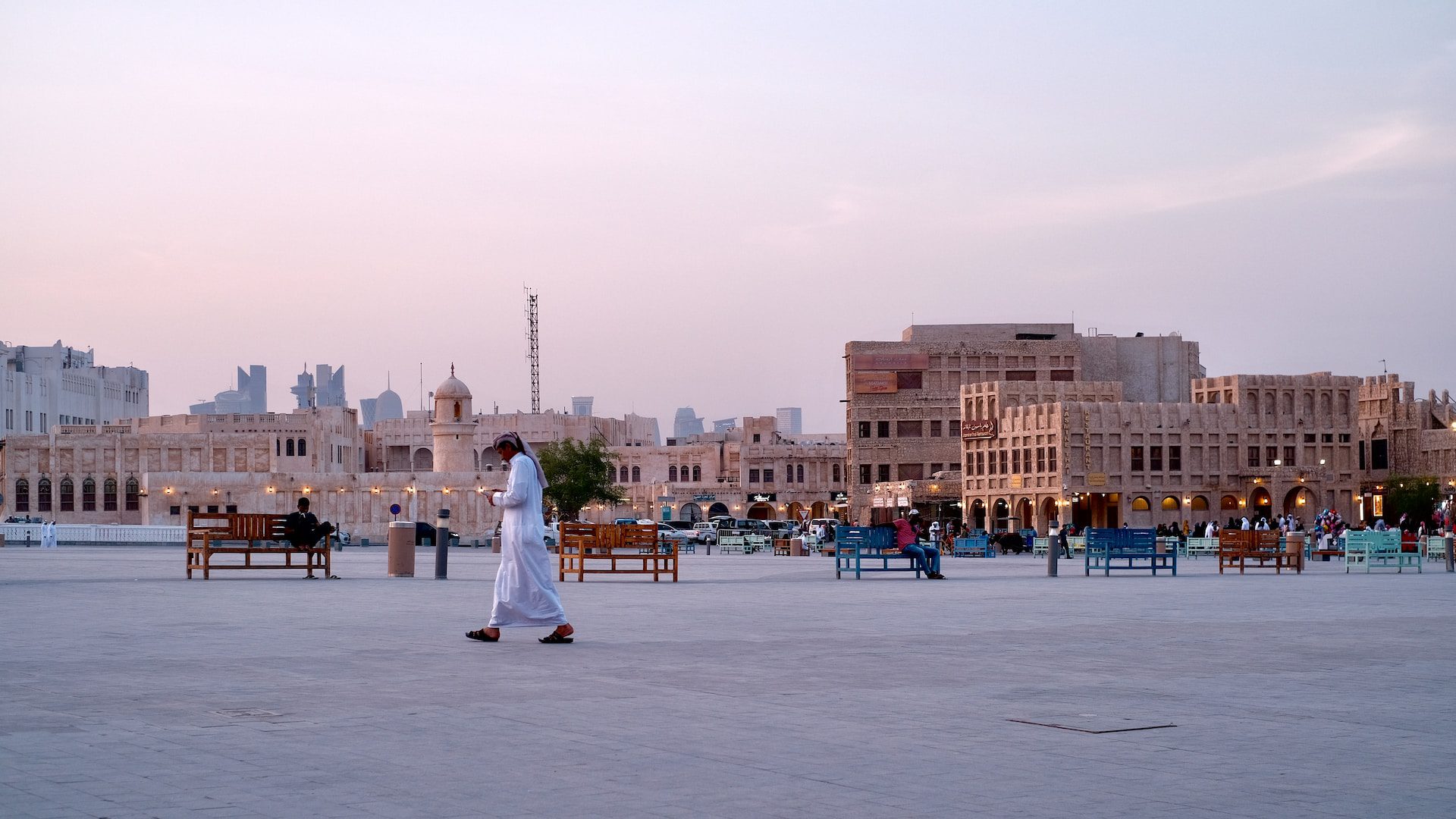 Souq Waqif at sunset with stalls and people in the square.