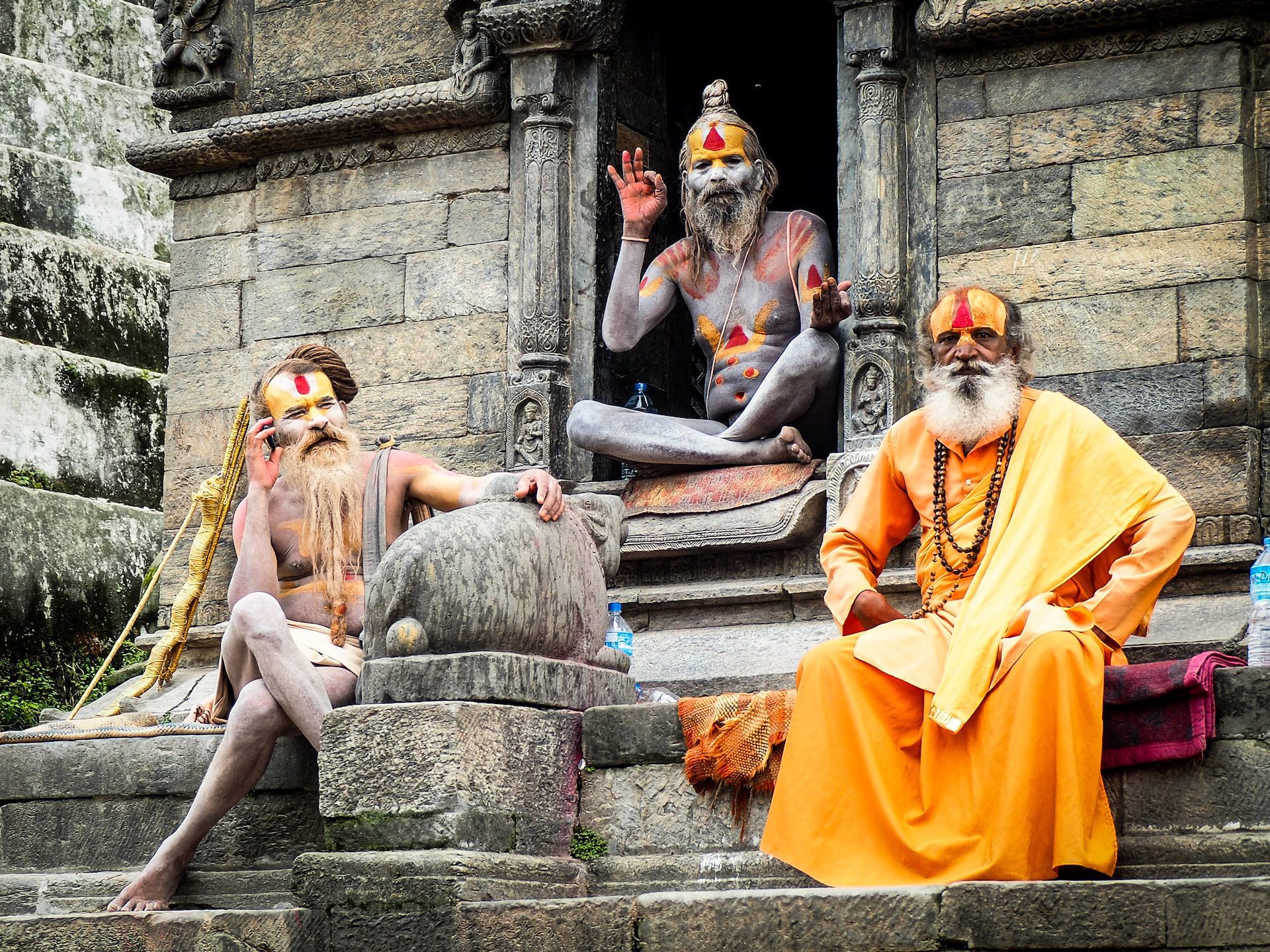The holy men of Pashupatinath Temple, dressed in yellow robes and with orange and yellow paint on their faces.