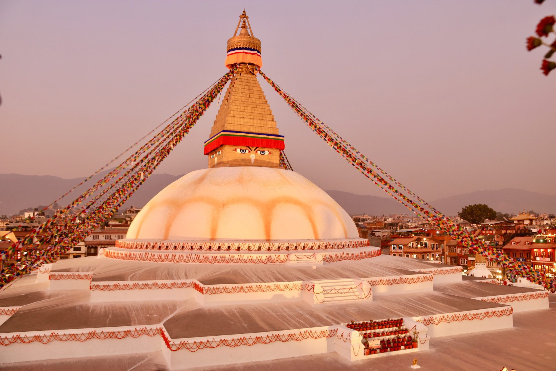 A large white dome with a gold spire on top, with eyes painted on it and grey skies above.