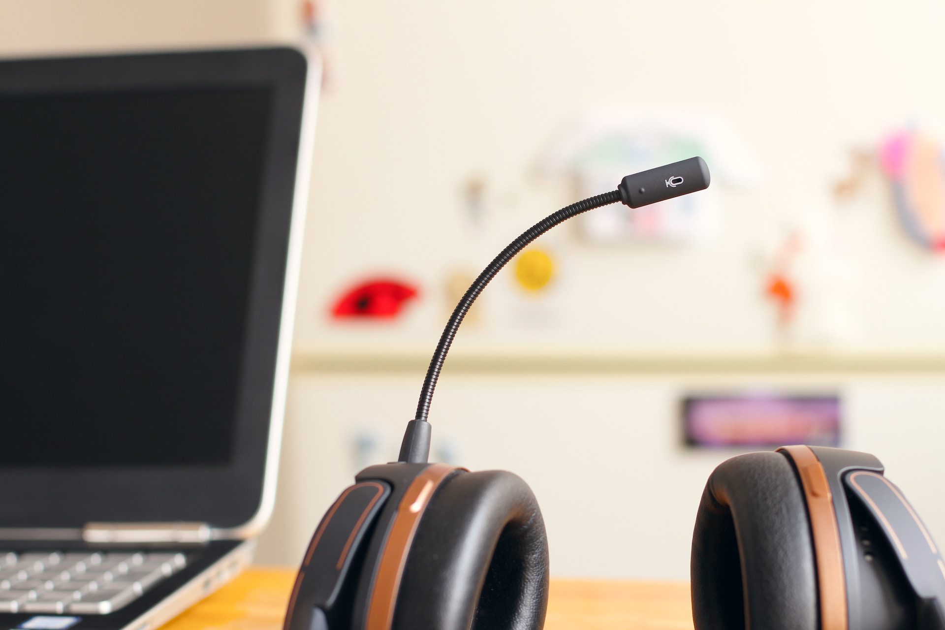 A customer service headset on the table next to a laptop.