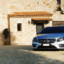 A silver Mercedes Zakynthos Taxi parked outside of a stone-walled villa.