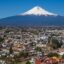 View of a snow-tipped mountain overlooking Puebla, with blue skies above.