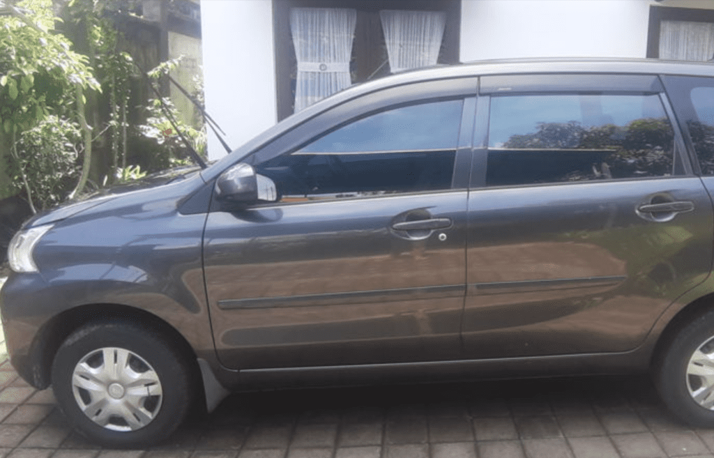 A grey/silver Bali Airport taxi (sedan) for your transfer.